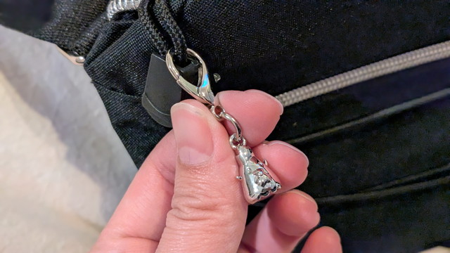 ショルダーバッグの金具部分アップ（カラビナと小さなシルバーチャーム）