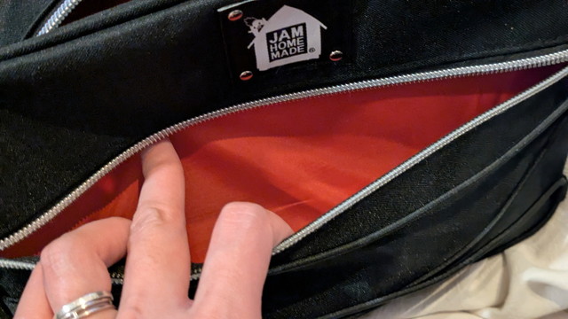 ショルダーバッグのメイン収納を開けたところ（オレンジの裏地が見える）