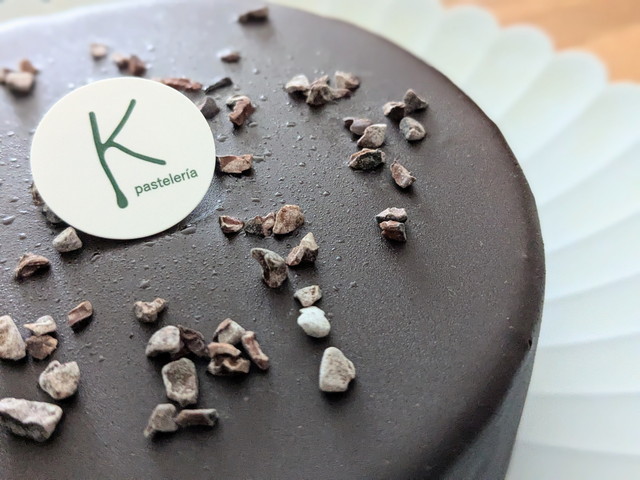 チョコレートケーキ上のカカオニブとロゴプレートのアップ