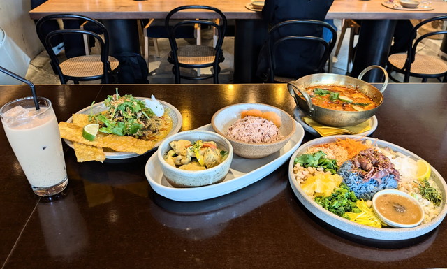 CHOMPOOの店内テーブルにグリーンカレー・カオヤム・スープなどカラフルなタイ料理が並んでいる