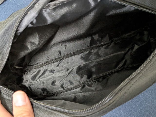 バッグ内側のようす。ブラックのライニングにファスナーポケットとオープンポケットが備わっている