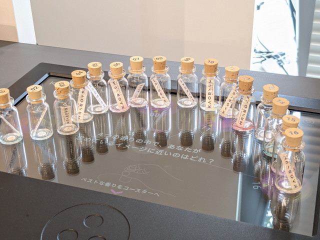 Chat→Fragranceコーナーの全景。多数のフレグランスボトルと中央の端末が並んでいる