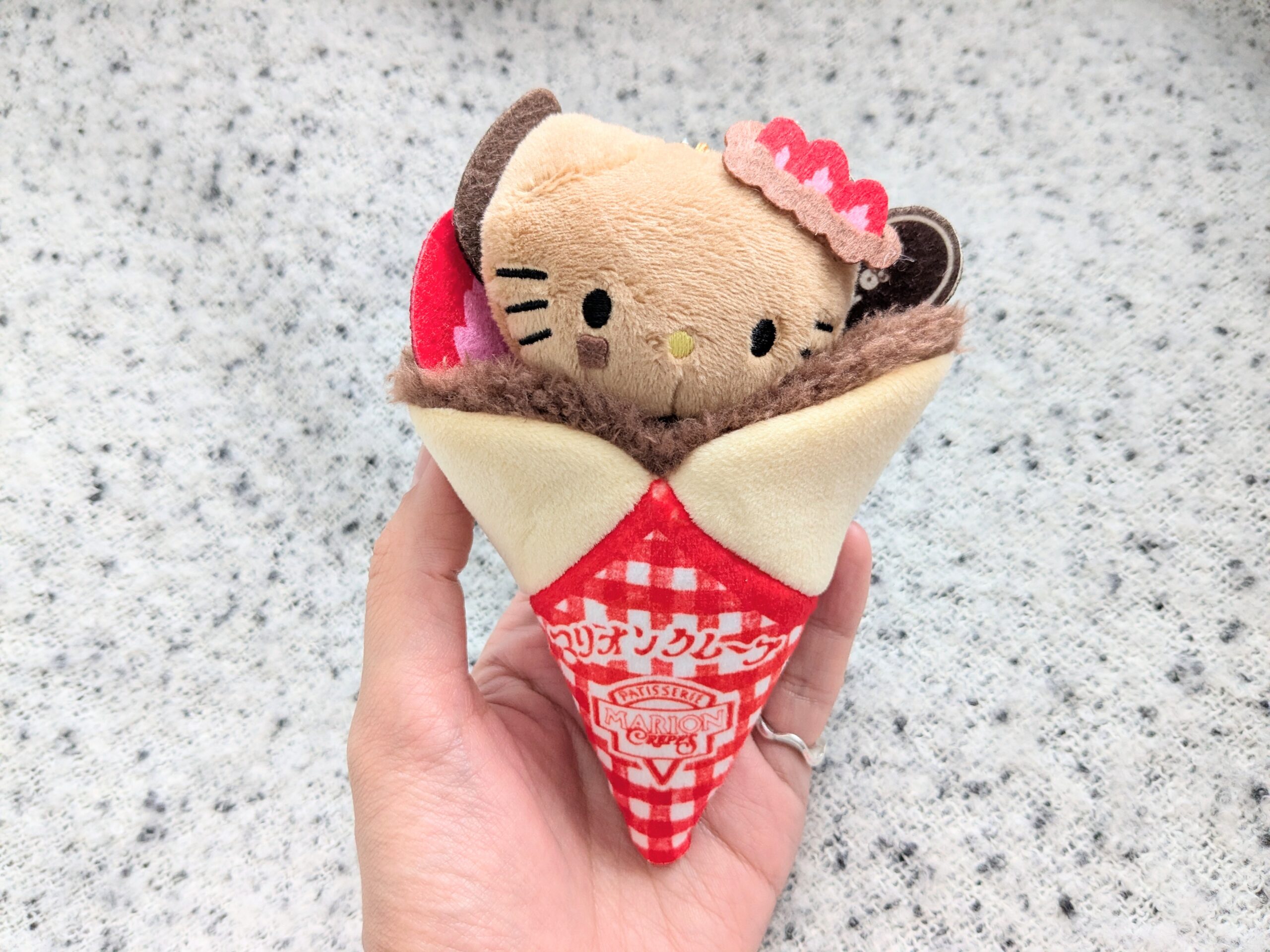 マリオンクレープ×HELLO KITTYいちごチョコショコラver.を手に持ったアップ