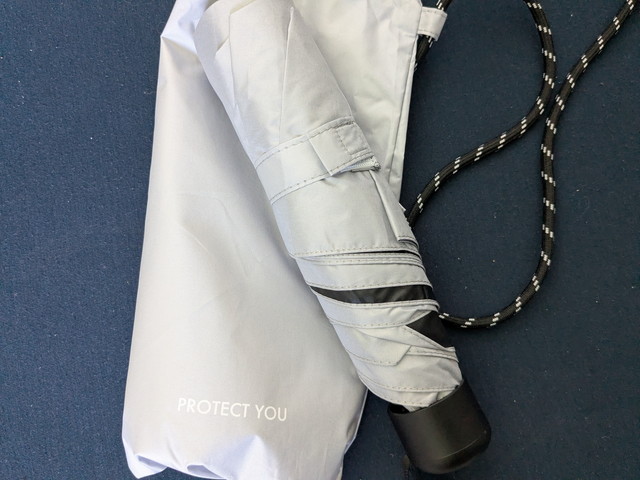 PROTECT YOUロゴ入りの折りたたみ傘と白い撥水ポシェットのアップ