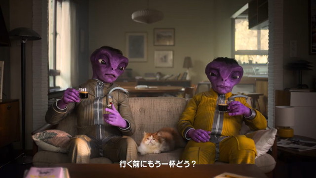 宇宙人2人がソファでコーヒーを楽しみながら「行く前にもう一杯どう？」というシーン
