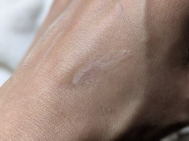 ピメル毛穴あざむき下地を手の甲に伸ばしている途中の様子