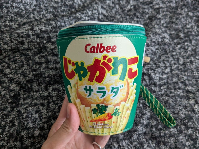 じゃがりこ サラダのパッケージそっくりなポーチ正面を手に持っている