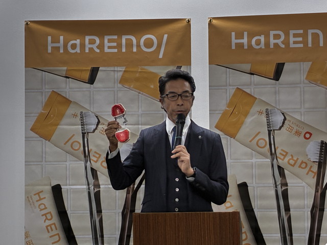 西尾秀俊さんがセミナーで奇跡の歯ブラシを手に持ちながらブラッシング術を実演している様子