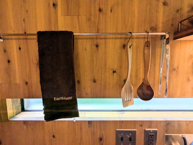 Earthboatのロゴ入りタオルとキッチンにかけられた調理器具