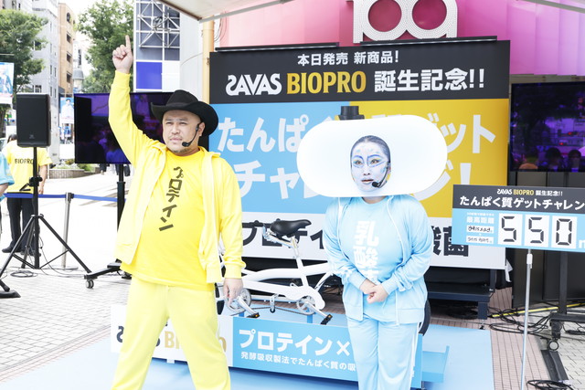 黄色いジャージのハリウッドザコシショウさんと水色の衣装のキンタロー。さんが並んでポーズをとる写真