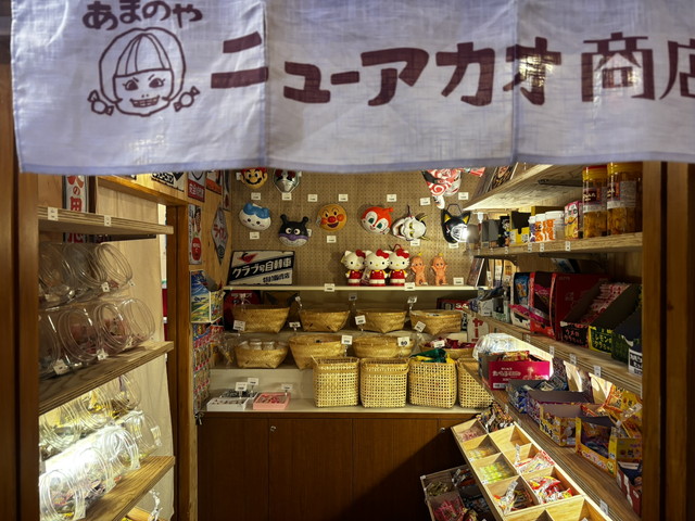 駄菓子屋の店内、お面やお菓子が並ぶ商品棚