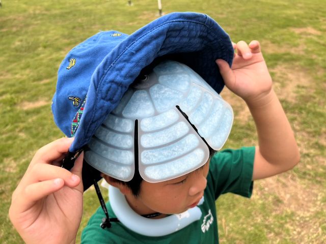 帽子の中にヘッドクールパッドを装着した子どもの様子