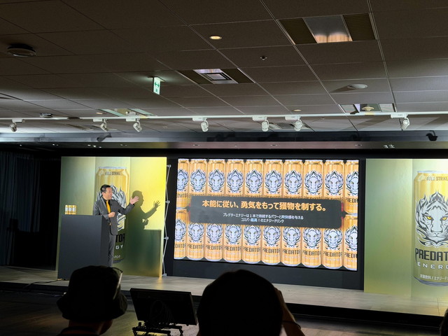 「本能に従い、勇気をもって獲物を制する。」と映し出されたスクリーンの前で講演するアサヒ飲料の登壇者