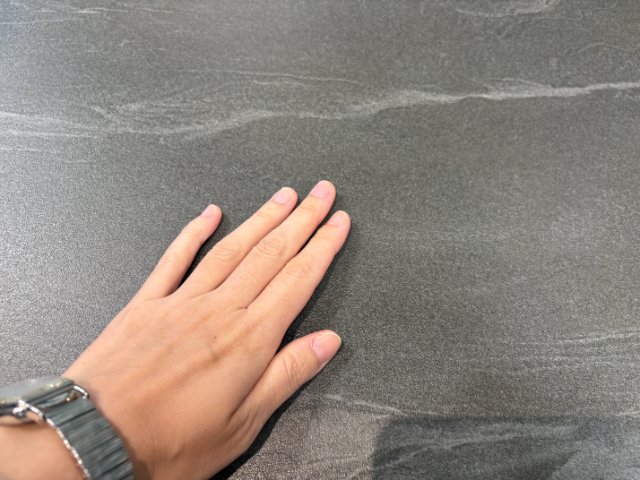 温まった天板に手を置いている様子