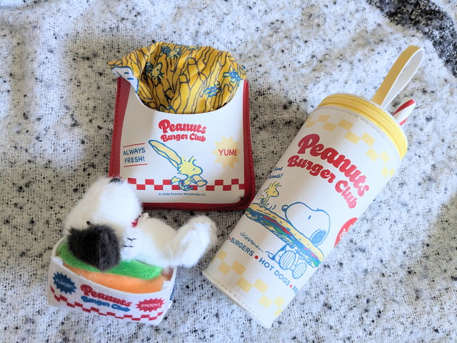ホットドッグの上でくつろぐスヌーピーのぬいぐるみチャーム